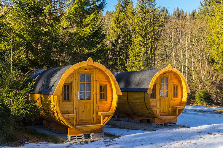 Schlaffässer zwischen Bäumen auf dem Campingplatz